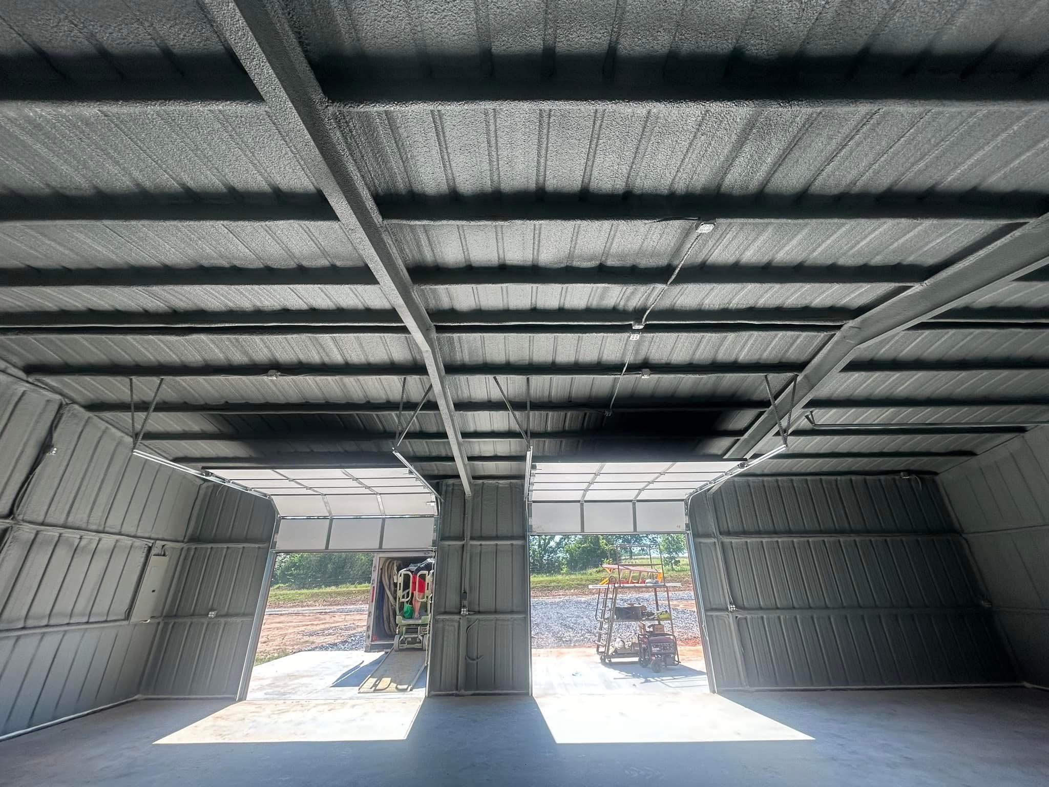 A bare metal building interior before spray foam insulation — exposed steel framing with no thermal protection.