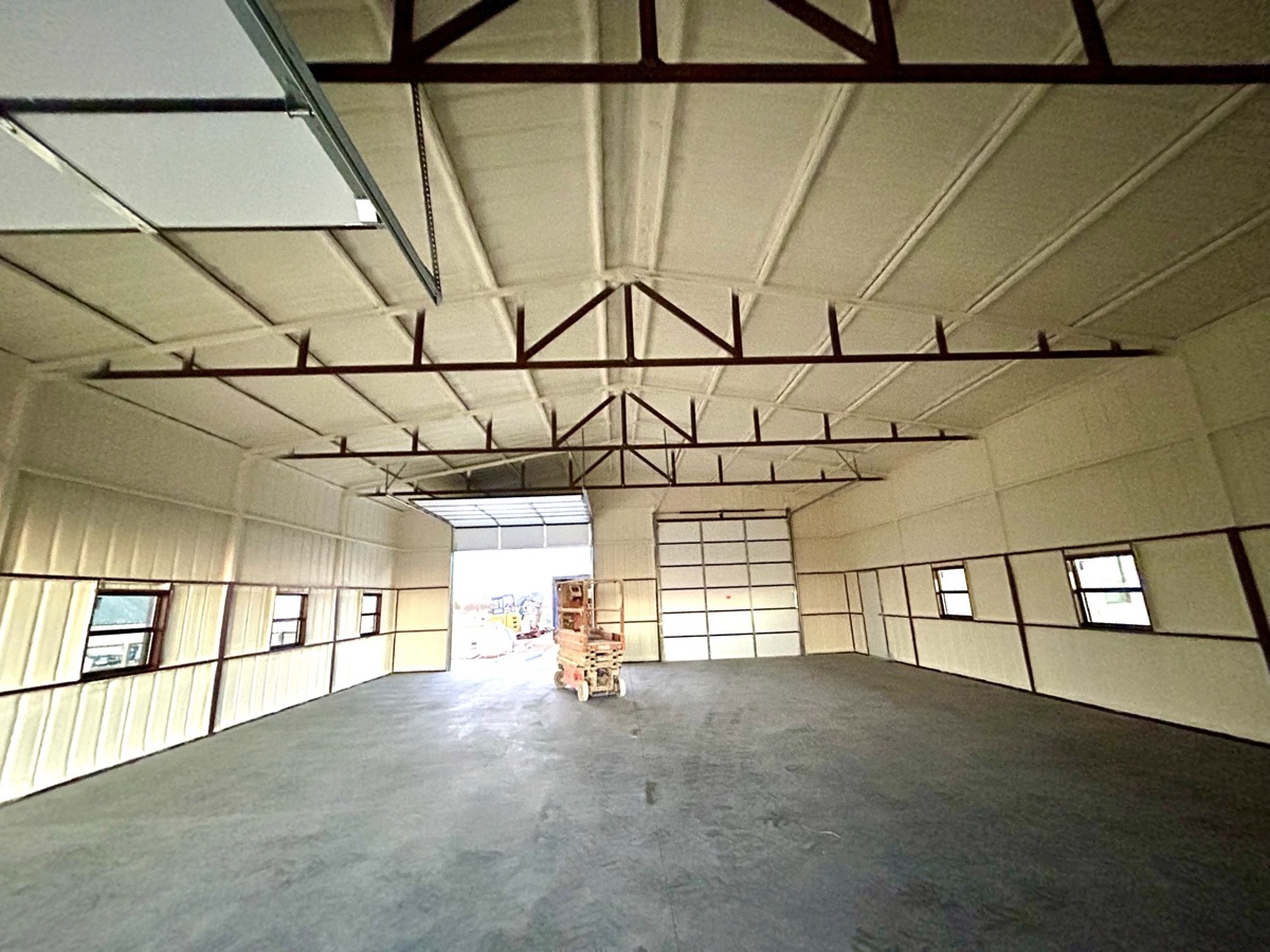 Wide-angle view of a large metal building interior fully insulated with closed cell spray foam in Oklahoma.