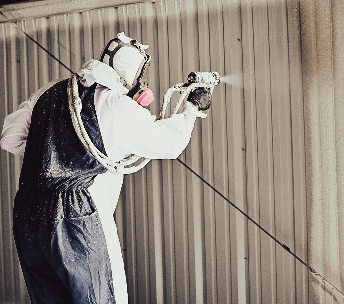 Spray foam insulation contractor spraying a metal building wall in Oklahoma — our team in action.