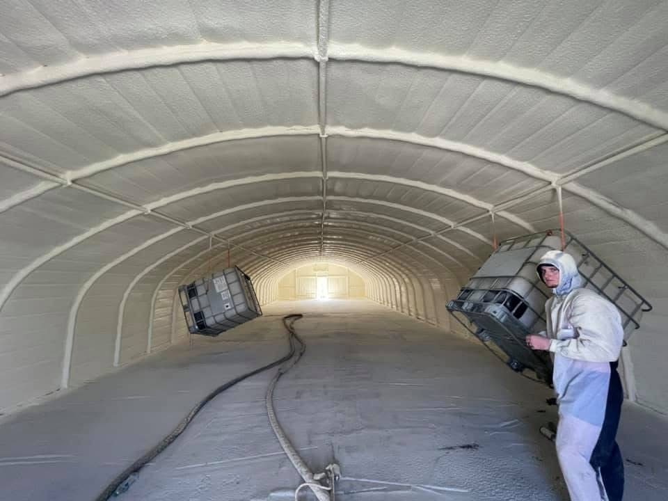 Spray foam insulation fully applied inside a quonset hut arch building — complete coverage on curved surfaces.