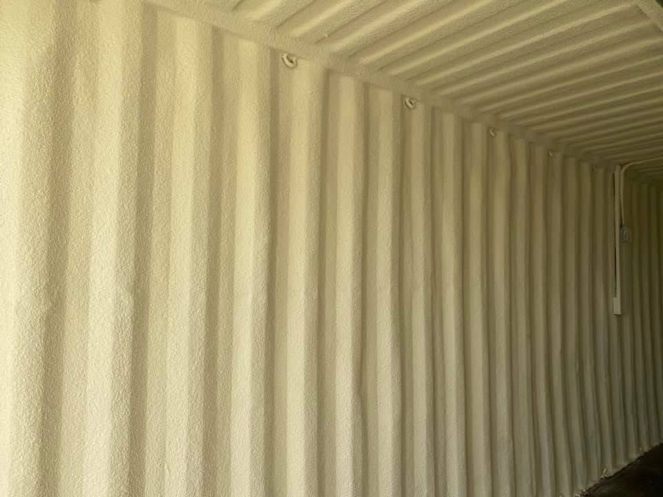 Spray foam insulation applied to the interior of a shipping container in Oklahoma for climate-controlled conversion.